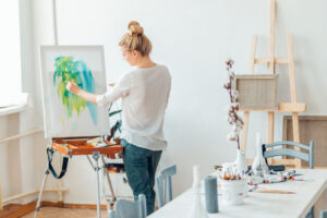 woman painting artwork on a canvas