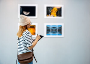 young woman at an art gallery writing notes