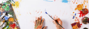 painter painting on canvas with paintbrush from above