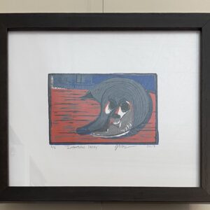 Intertidal Decay" by Alexander Haas is framed art of a dark sea creature on a red and blue background.