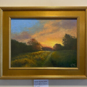 Late Afternoon Delight" by Elizabeth Craumer is a framed landscape of a sunset over a grassy field and trees.