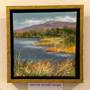 Perkins Pond" by Betty Glass is a framed landscape of a river, grassy shore, trees, and distant mountains.