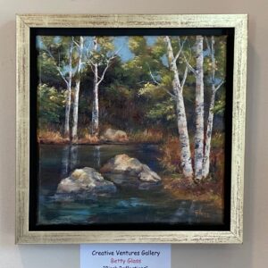 Birch Reflections" by Betty Glass: a framed forest scene with birch trees, rocks, and a reflective pond on display.