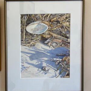 Framed art from Saturday Watercolor Painting Class with Diane Orzel features a shell and driftwood on sandy ground.