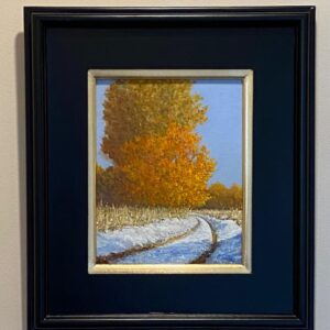 “Morning Glory” by James O’Donnell, a framed painting of a snowy path and autumn trees, hangs on a beige wall.