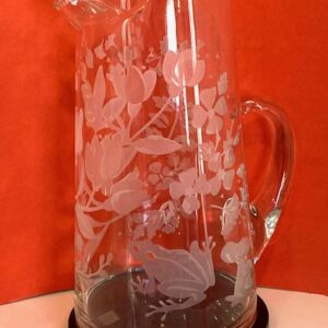 Floral/Fauna Pitcher" by Tara Van Meter, clear glass with etched floral and frog design on an orange background.